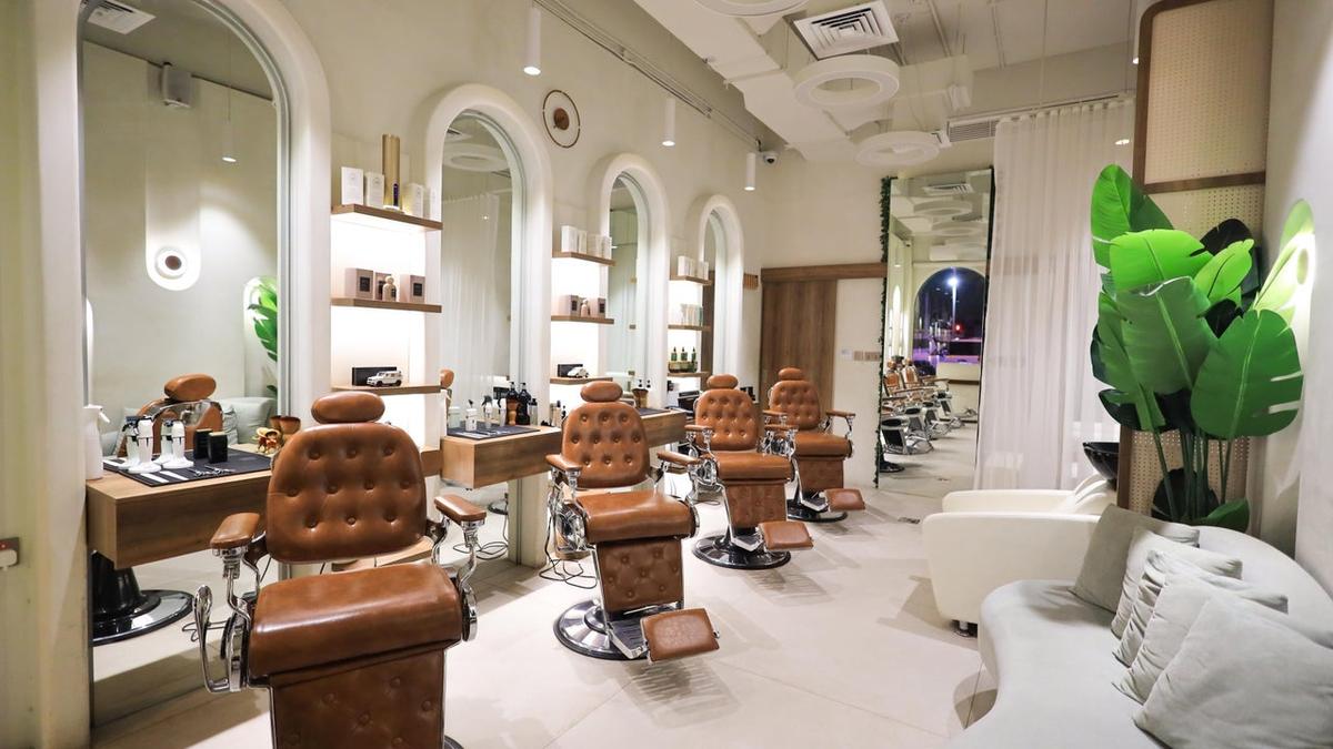 Caramel leather barber chairs in front of arched mirrors