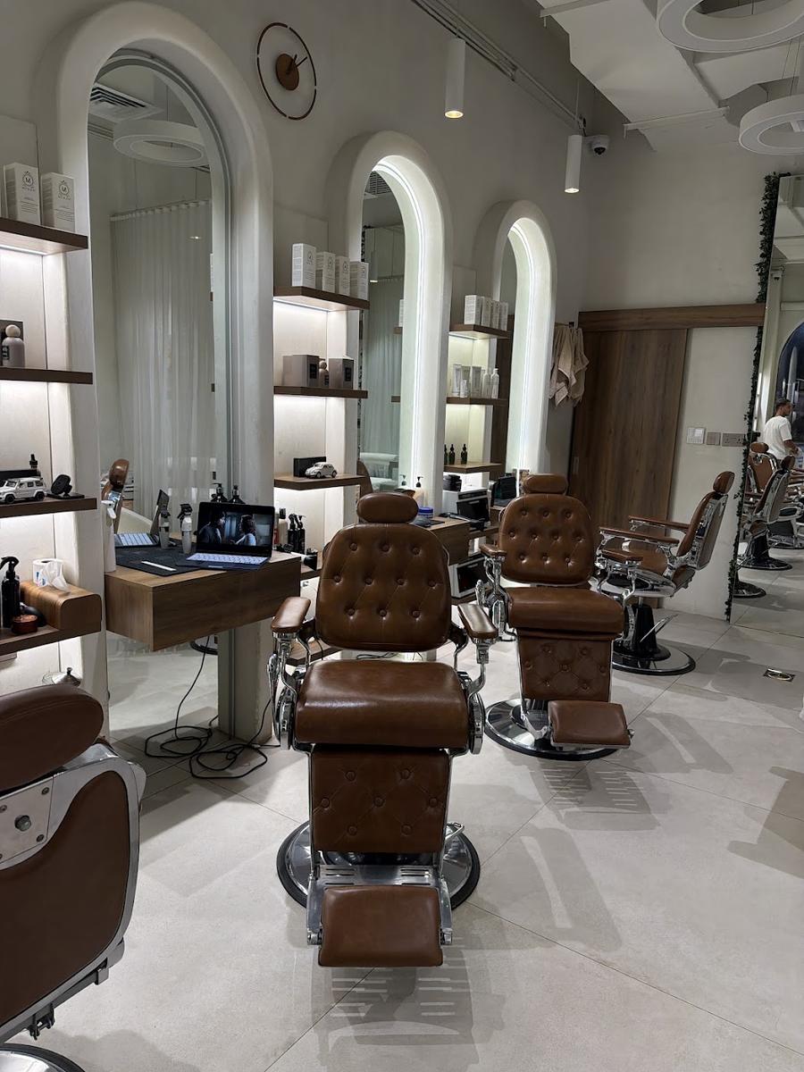 Inside Adam NQ: arched mirrors, caramel barber chairs and plants